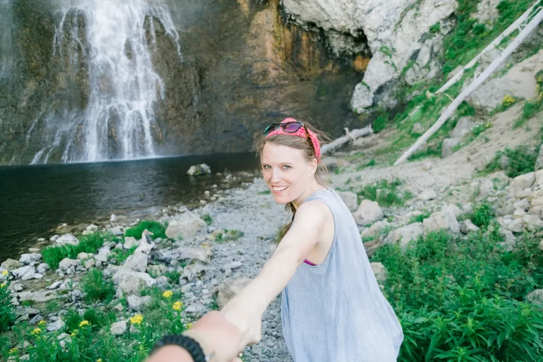 woman-holding-hand-waterfall
